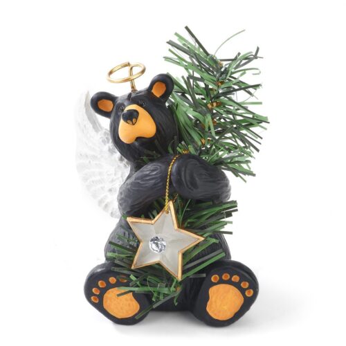 A teddy bear figurine holding a star and a Christmas tree.