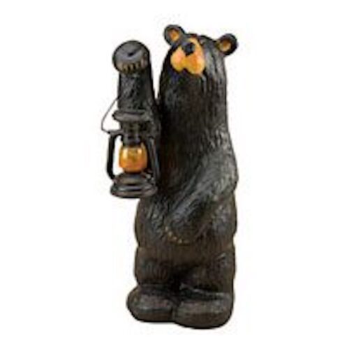 A black bear figurine holding a lantern.