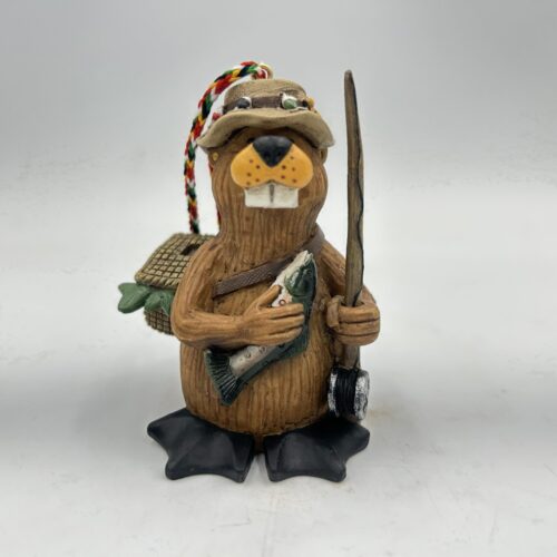 Wooden tiki figure holding a spear and a small green item, wearing sunglasses and a hat.