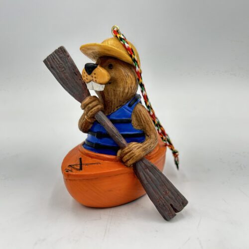 A wooden figure paddling a canoe with colorful beads on its head.