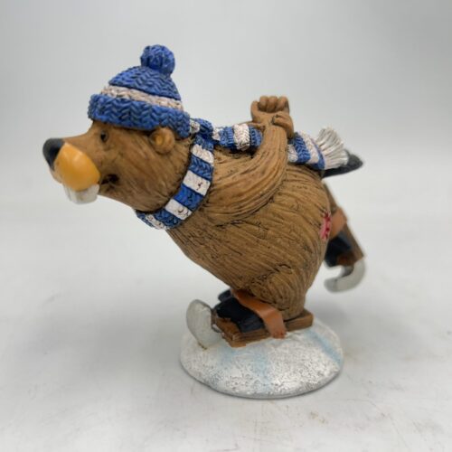 A figurine of a bear ice skating, dressed in winter clothes.