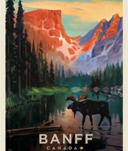 A moose stands by a peaceful lake with towering mountains in the background.