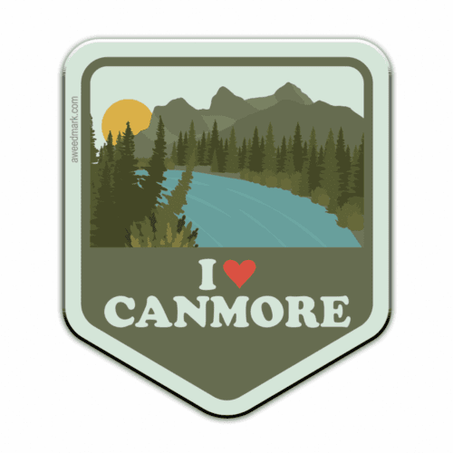 Scenic badge of Canmore with mountains, river, and forest at sunset.