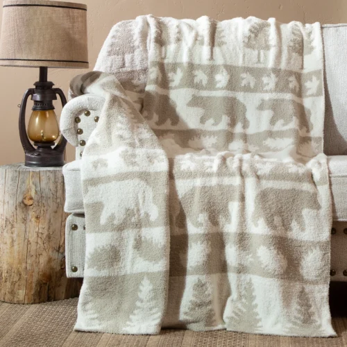 Soft beige and white elephant-patterned blanket draped over a chair.