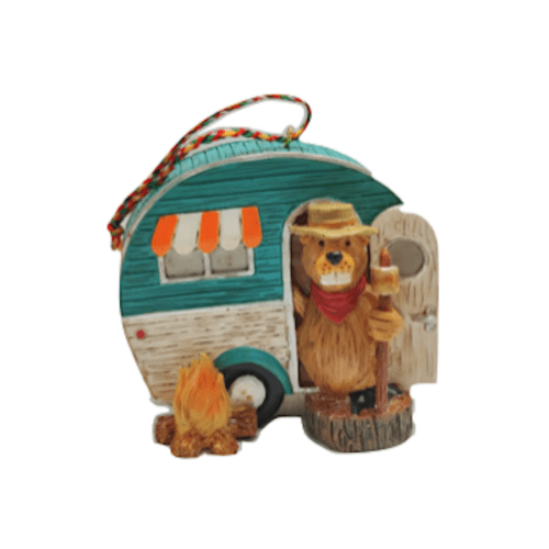 Bear figurine beside teal camper and campfire